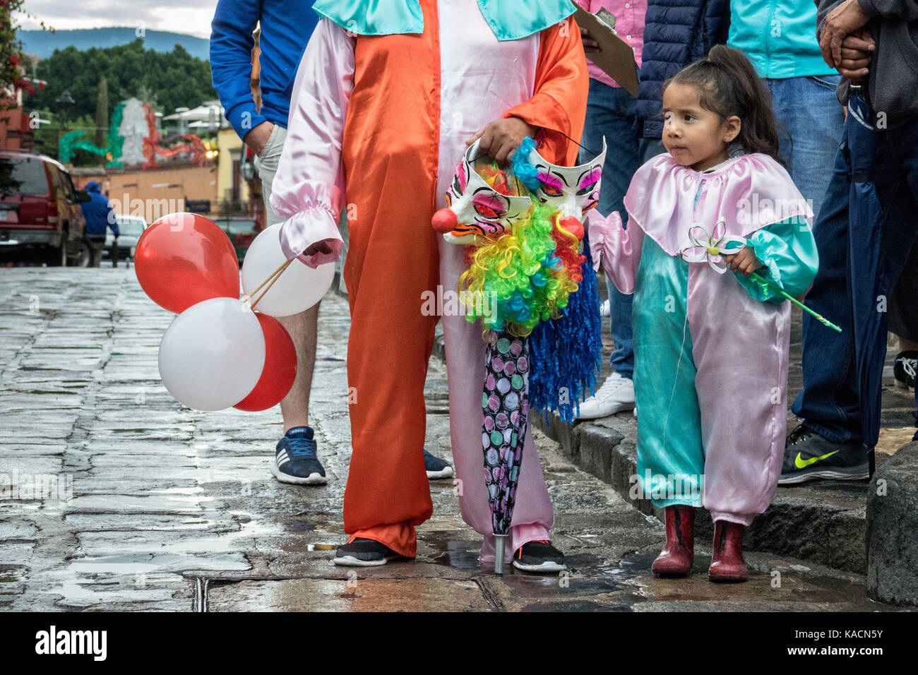 Ein junges Mädchen in Clown Kostüm Uhren eine Prozession durch den Jardin Allende während der einwöchigen Fiesta des Schutzheiligen St. Michael September 24, 2017 in San Miguel de Allende, Mexiko. Stockfoto