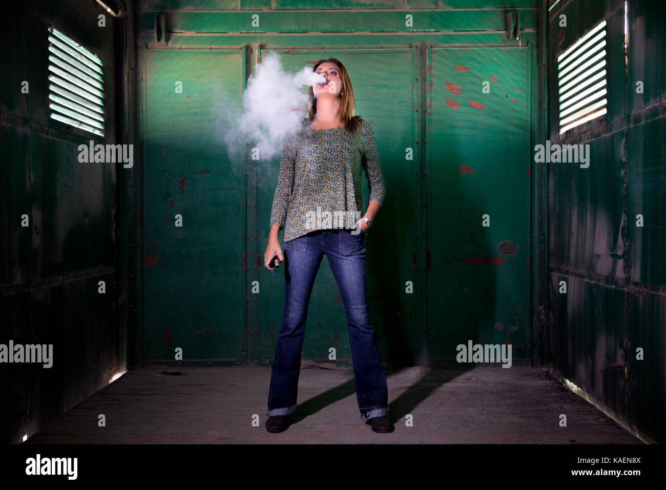 Frau vaping in einem Alten und Verlassenen Zug Wagen Stockfoto