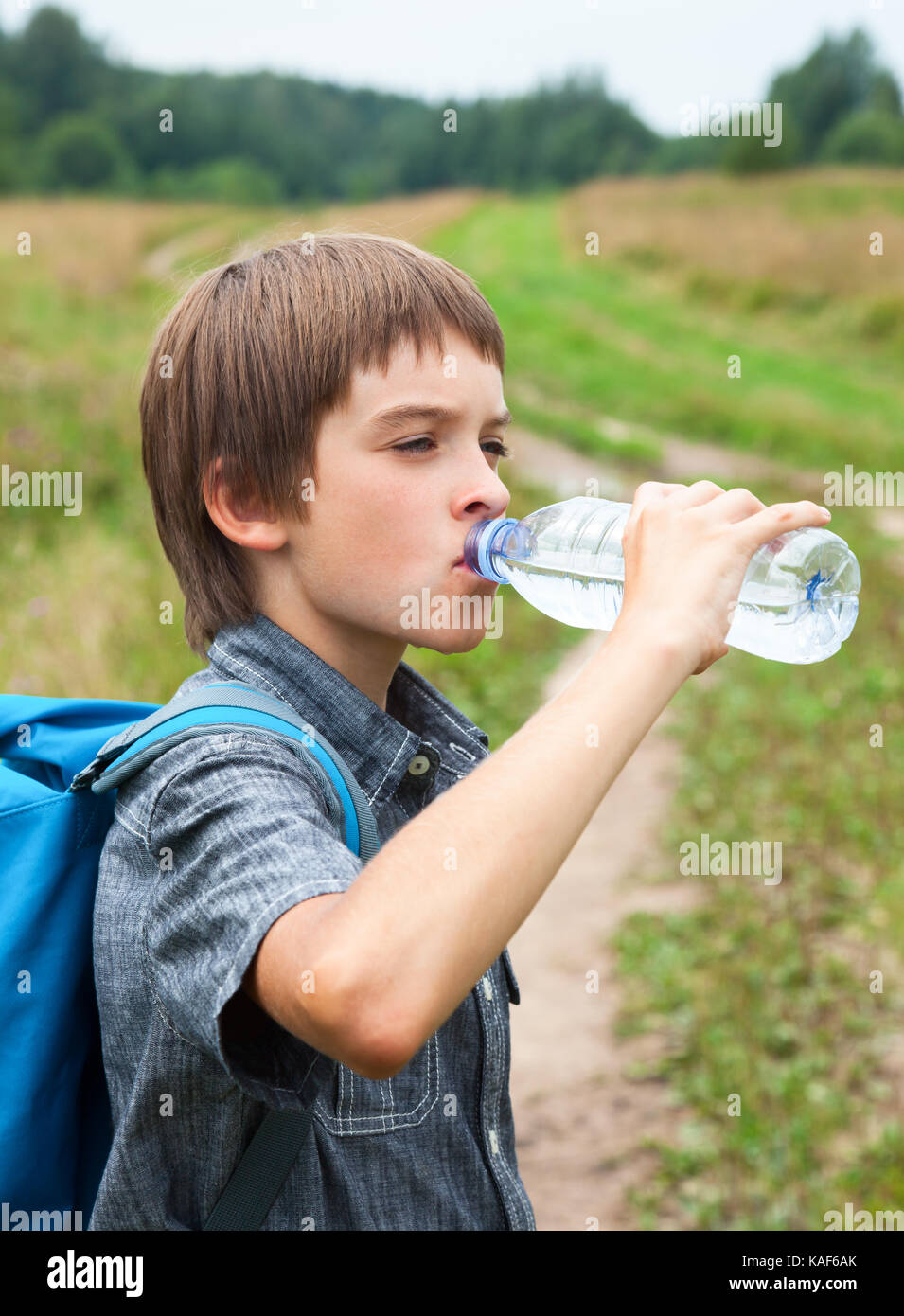Junge Trinkwasser aus PET-Flasche im Freien Stockfoto