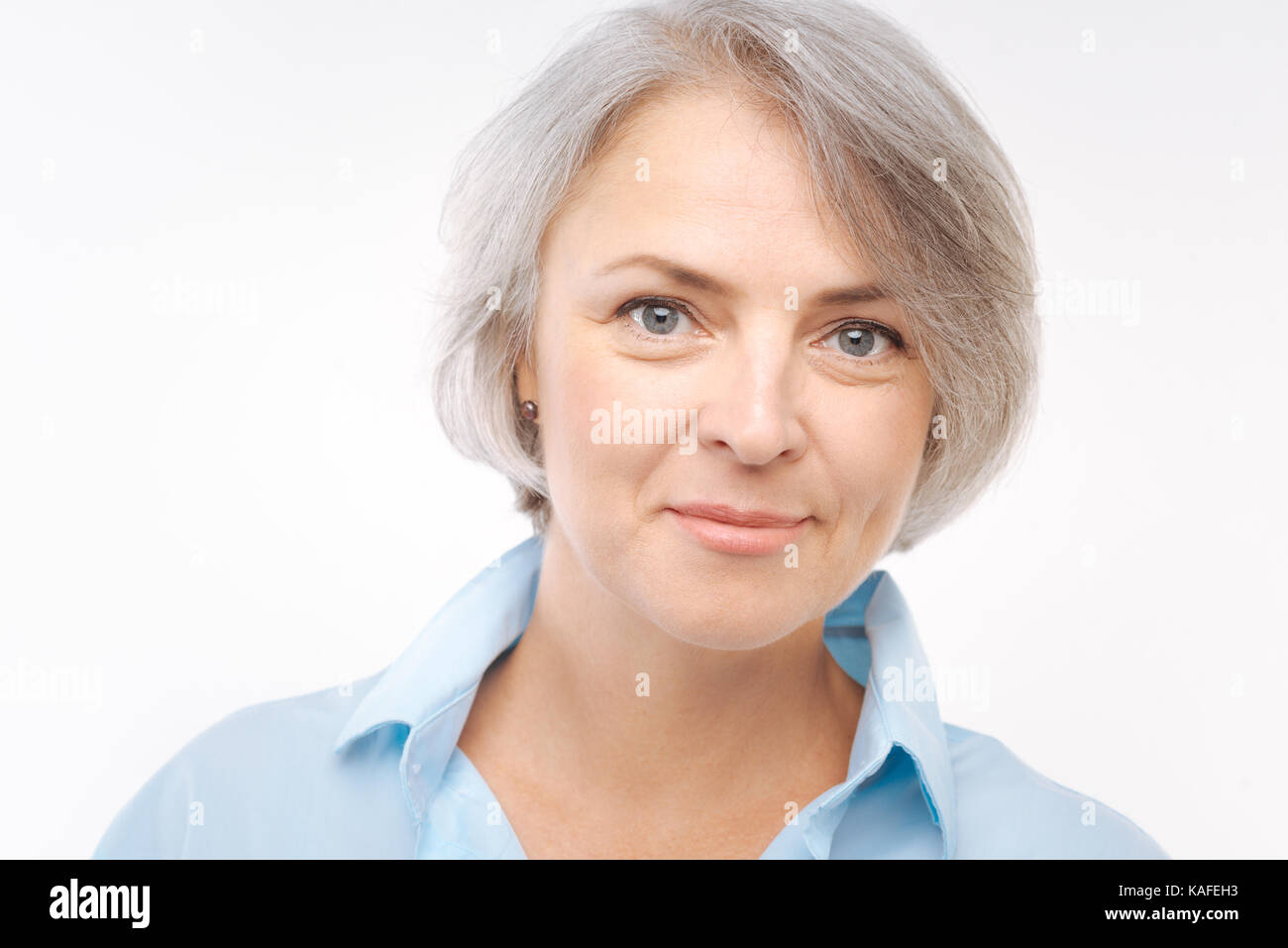 Charmante grauhaarige Frau in die Kamera lächeln Stockfoto