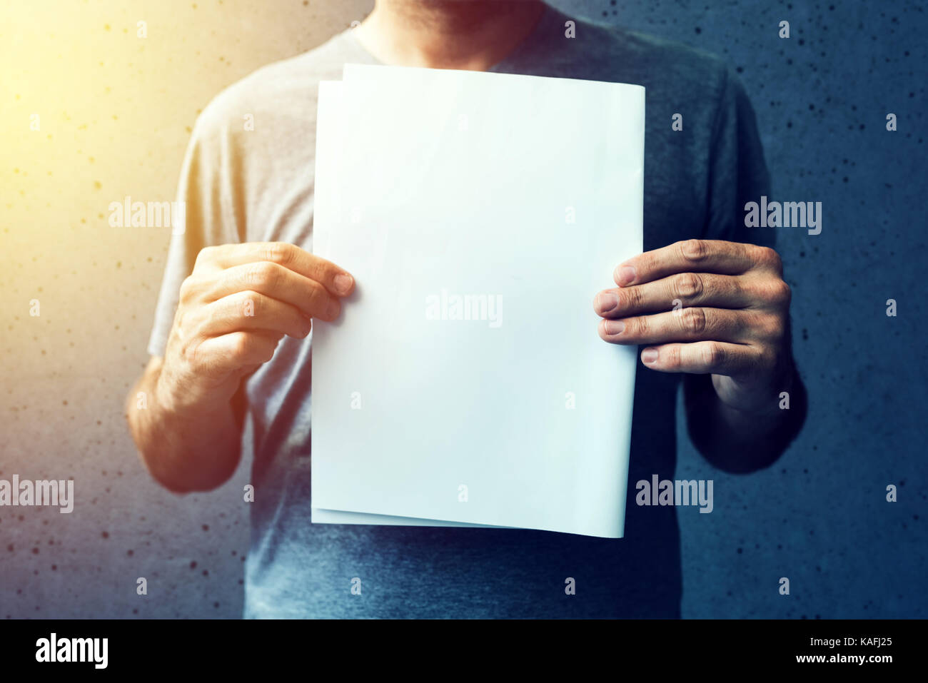 Legerer mann Holding leer A4 Papier als Mock up Kopie Platz für Text oder Grafik Design Stockfoto