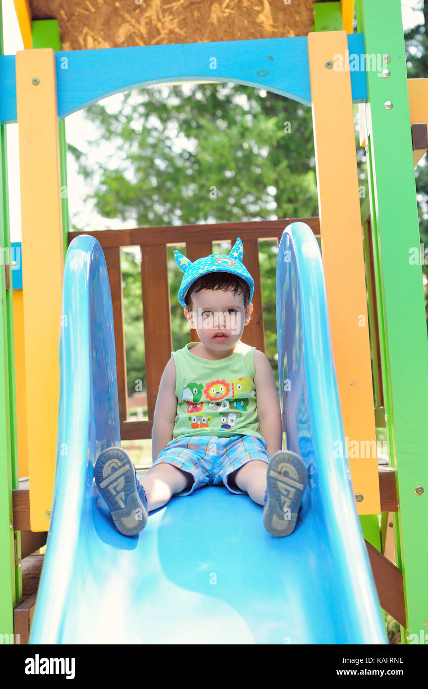 Kleiner Junge auf einem blauen Folie Stockfoto