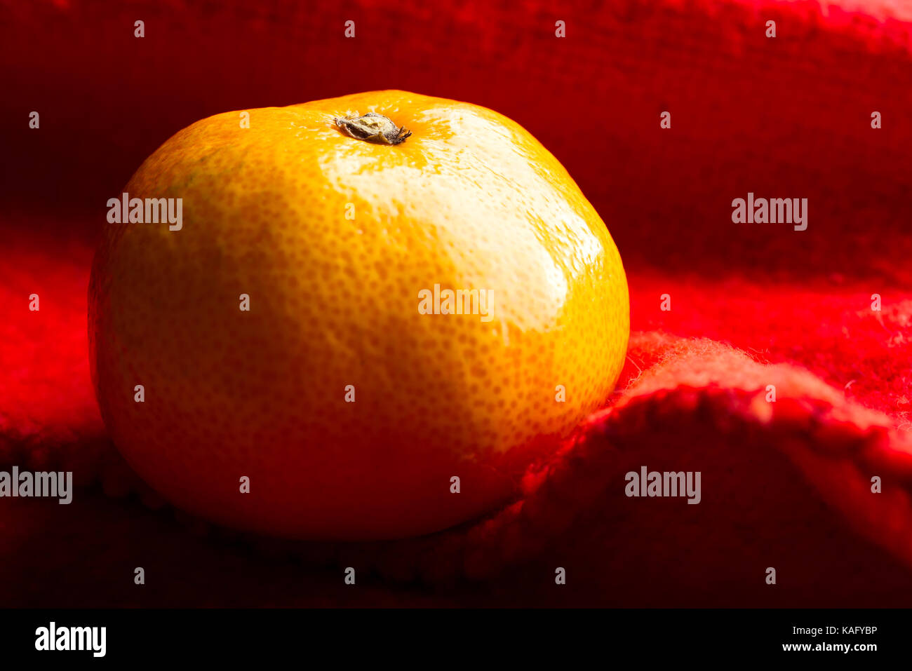 Eine satsuma Mandarin auf rote Picknickdecke Stockfoto