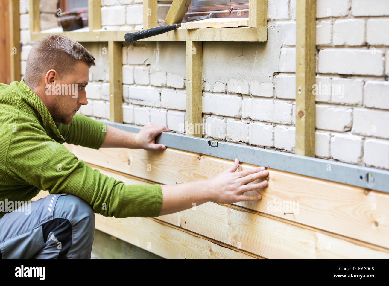 Bauarbeiter, der Kontrolle der neuen Haus Holz Fassade Stockfoto