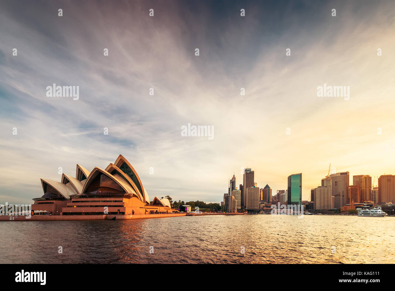Sydney, Australien - 10. November 2015: Opernhaus mit Sydney Skyline der Stadt bei Sonnenuntergang. Blick von der Fähre nähert sich Circular Quay. Stockfoto