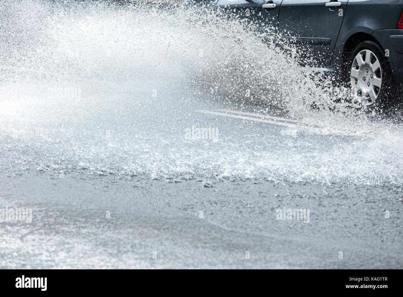 City Road mit Regenwasser überflutet. Um Spritzer Auto auf nasser Straße. Stockfoto