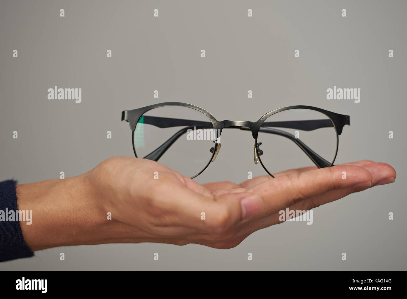 Gläser auf menschliche legen Hand bis auf grauem Hintergrund Stockfoto