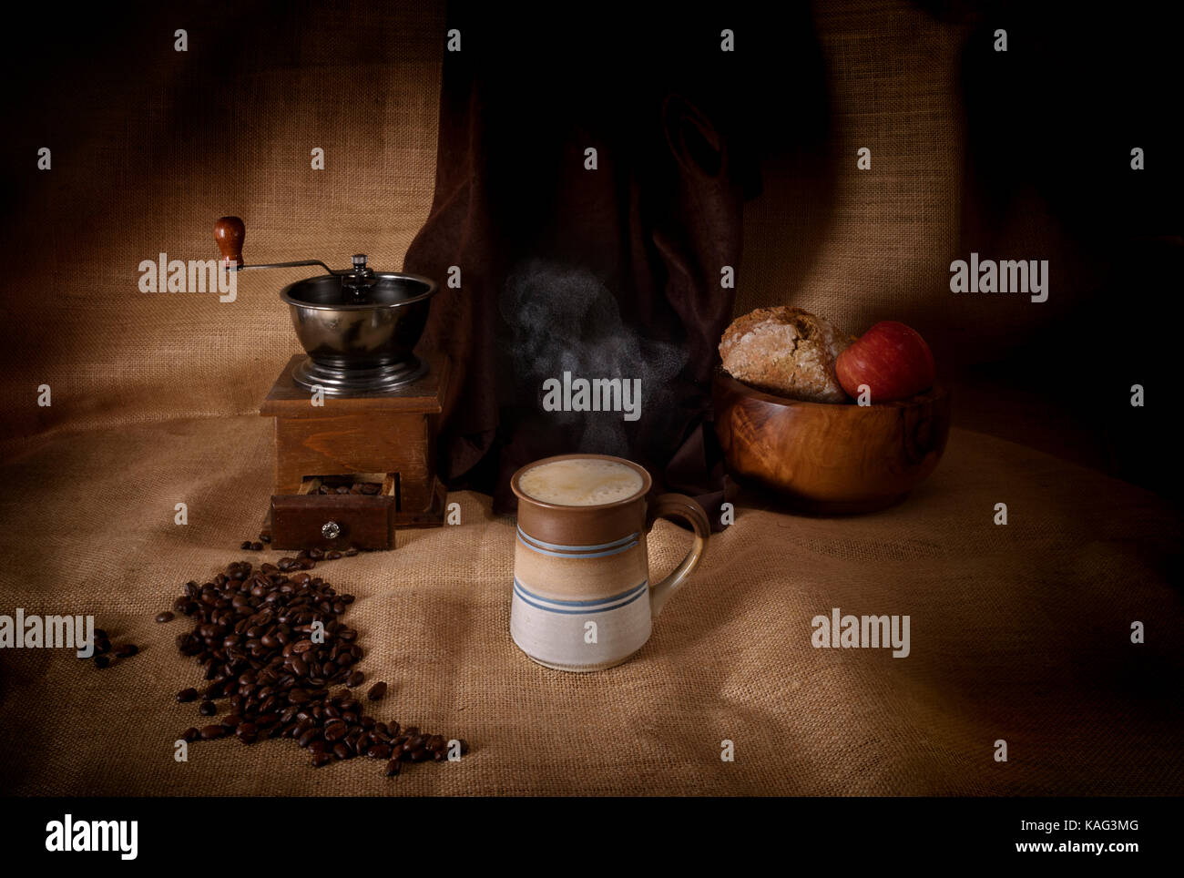 Dampfend heißes Getränk Kaffee in eine Tasse neben Kaffeemühle und Kaffeebohnen Stockfoto