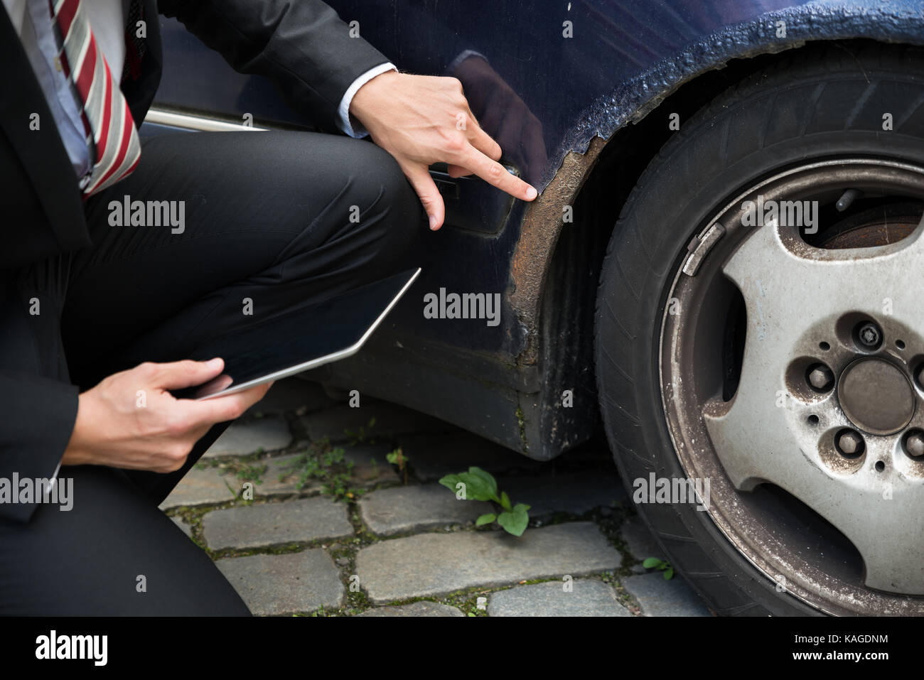 Versicherung Holding Digital Tablet Prüfung Auto beschädigt nach Unfall Stockfoto