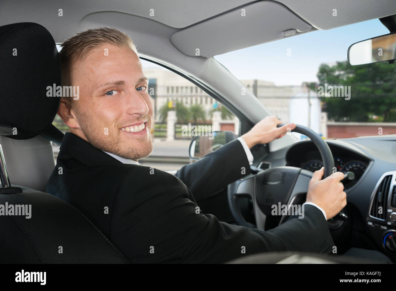 Portrait Of Happy Geschäftsmann, der in seinem Auto Stockfoto