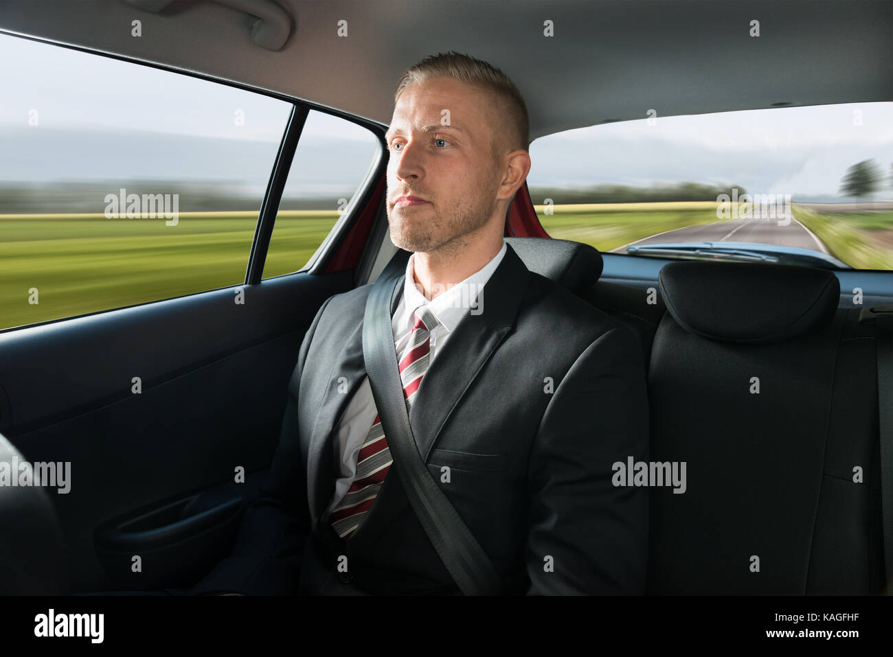 Portrait einer jungen Geschäftsmann in einem Auto unterwegs Stockfoto