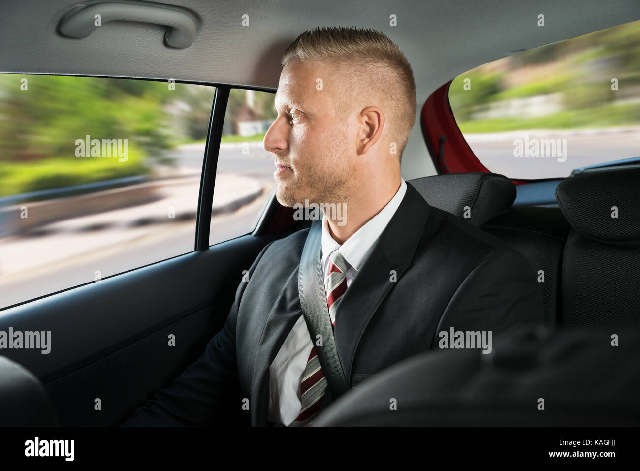 Portrait einer jungen Geschäftsmann in einem Auto unterwegs Stockfoto