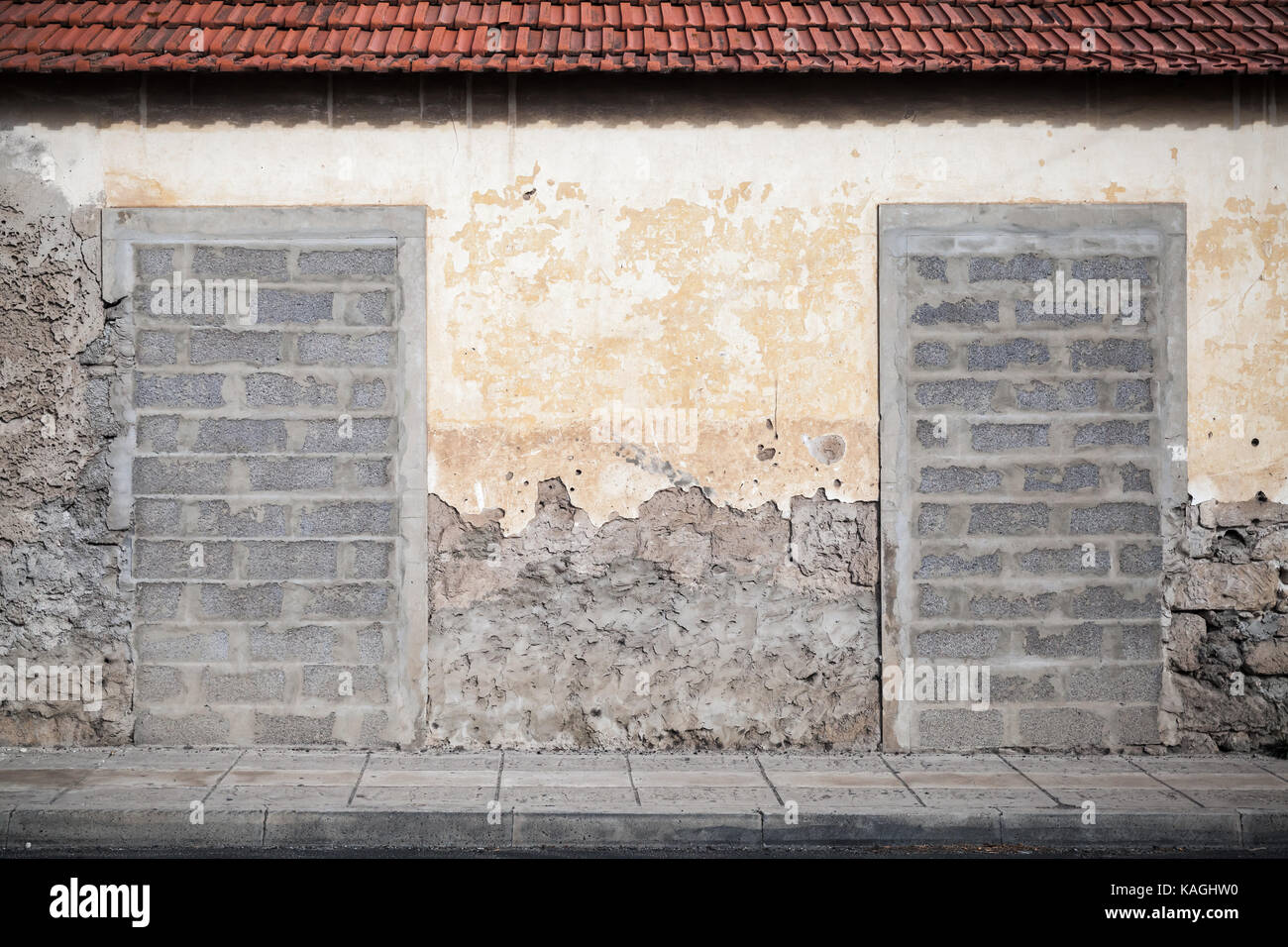 Zwei Türen in der alten gelben wand mit Beton Ziegel blockiert. Hintergrund Foto Textur Stockfoto