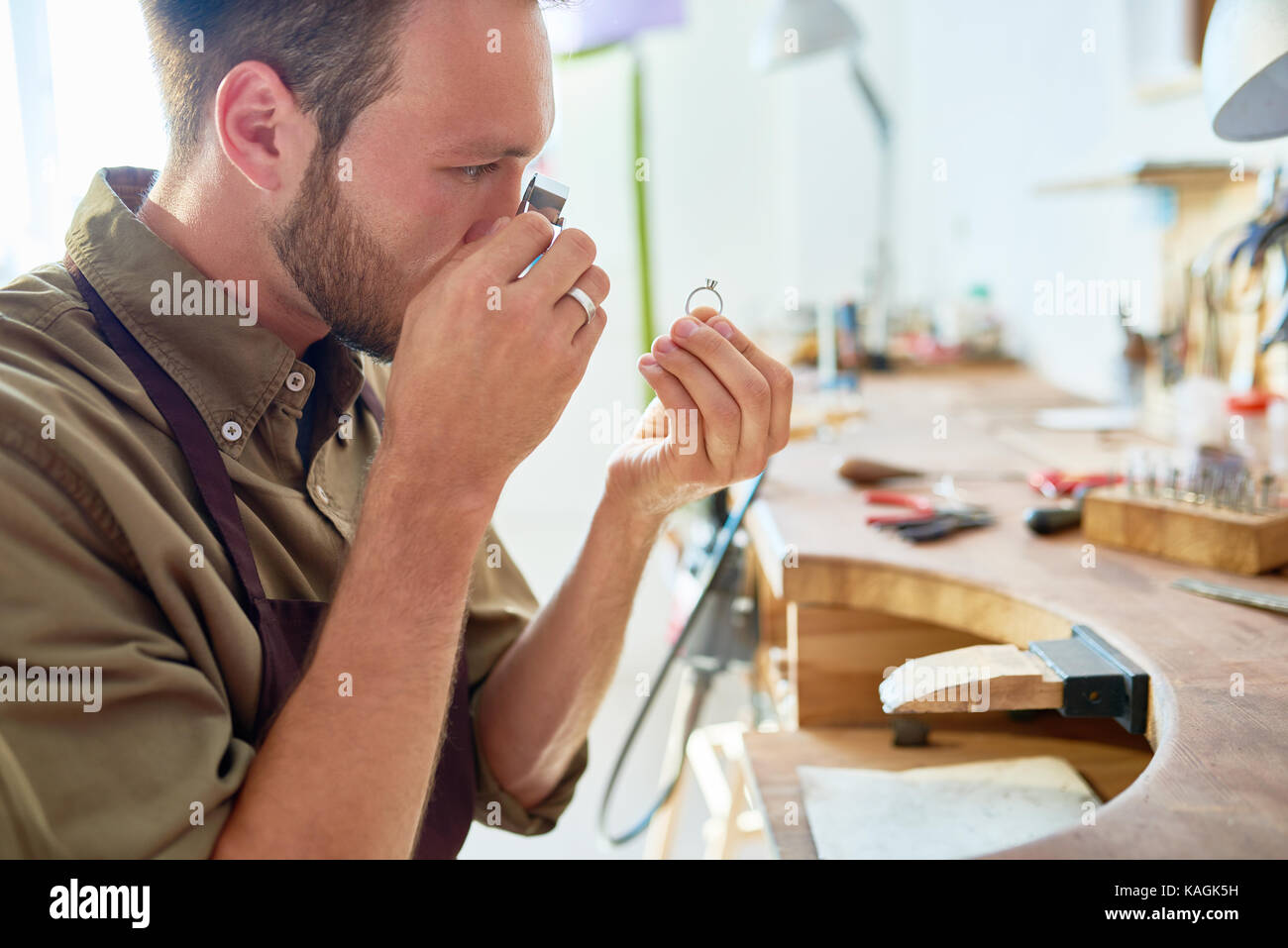 Junge Juwelier Beurteilung Ring im Shop Stockfoto