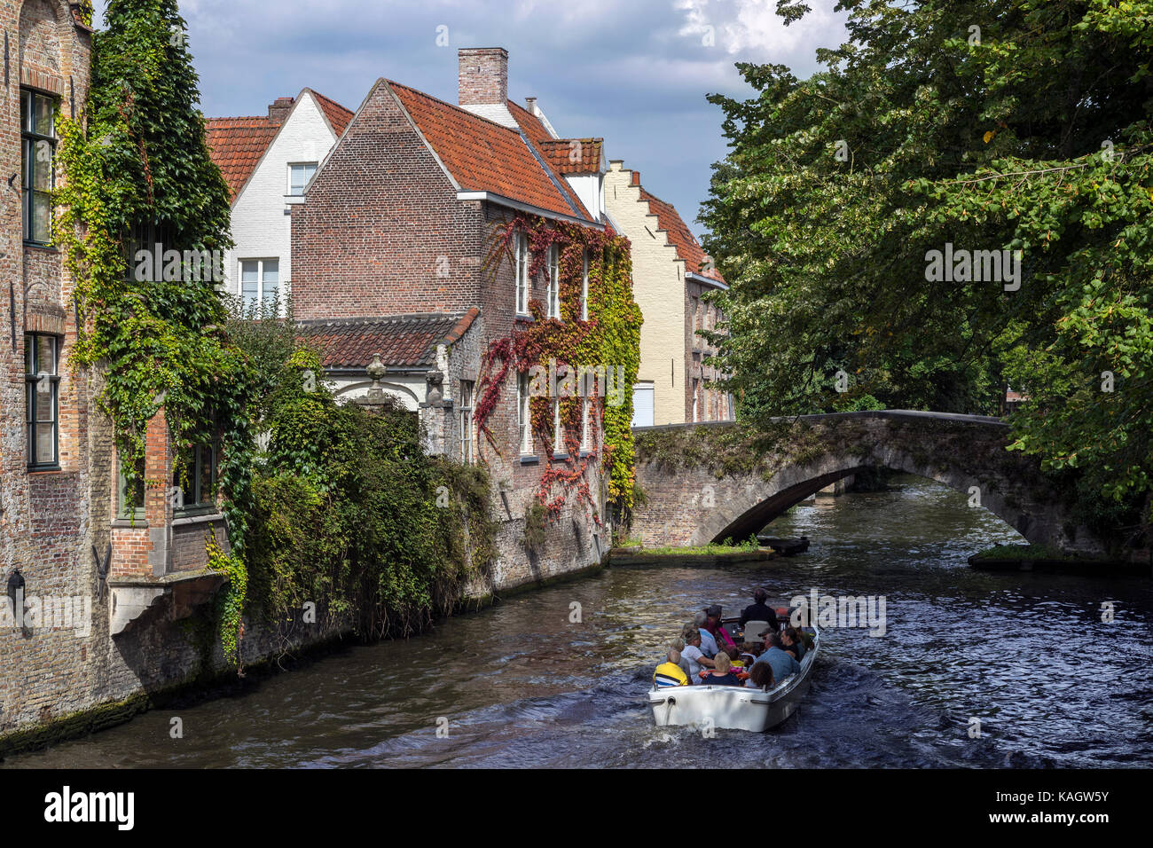 Touristische Bootsfahrt auf den Kanälen der Begijnhof Gegend der Stadt von Brügge in Belgien. Das historische Stadtzentrum ist ein UNESCO-Weltkulturerbe. Stockfoto