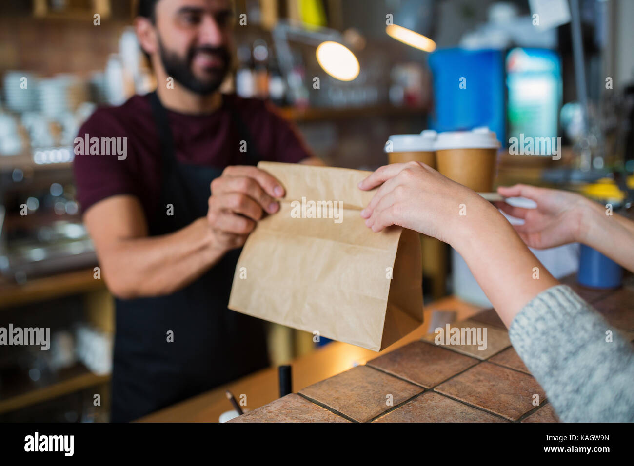 Mann oder Barkeeper Kunde bei Coffeeshop serviert Stockfoto