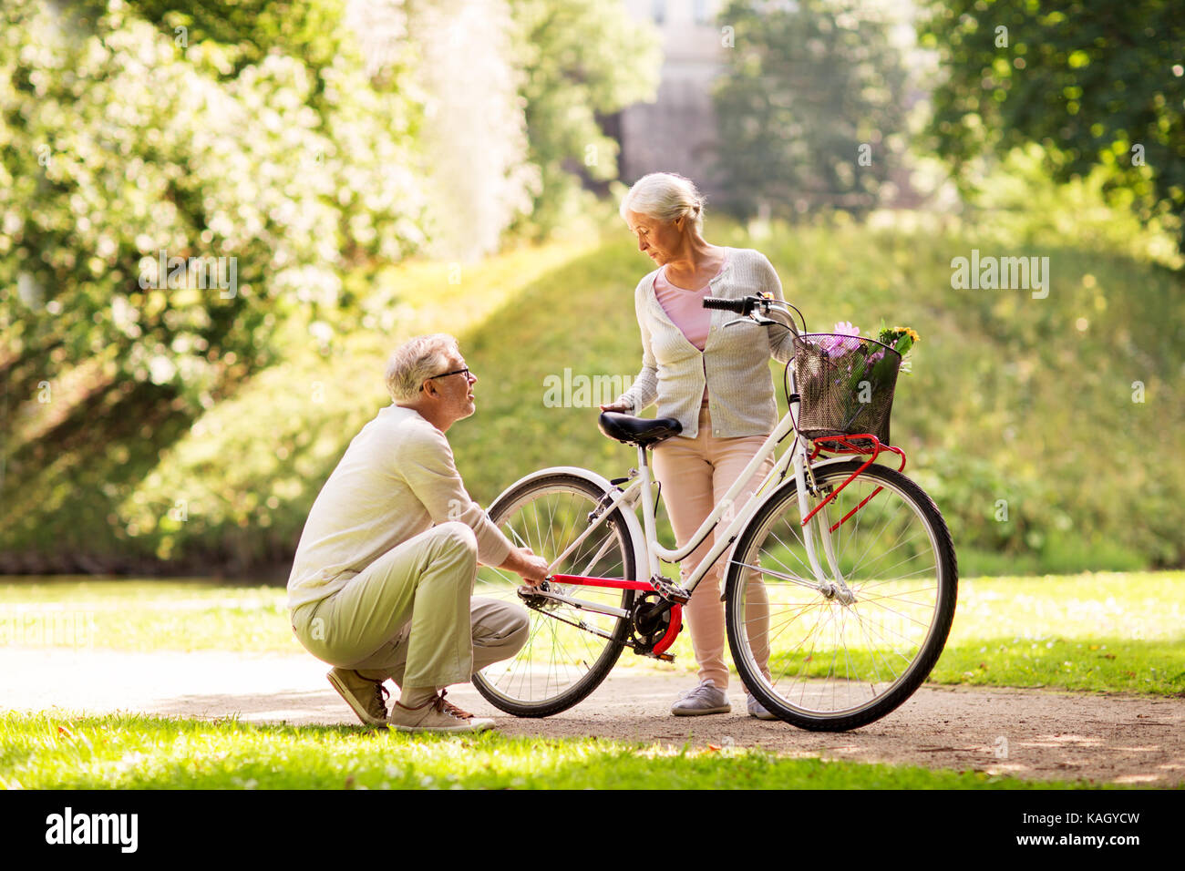 Gerne älteres Paar mit Fahrrad am Sommer, Park Stockfoto