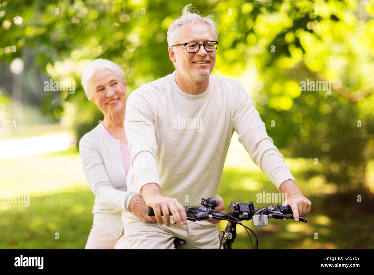 Gerne älteres Paar Reiten Fahrrad im Park Stockfoto