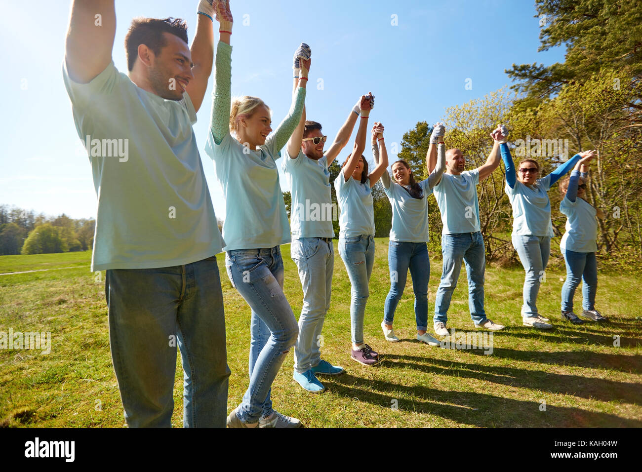 Gruppe von glücklich Freiwilligen Hand in Hand im freien Stockfoto