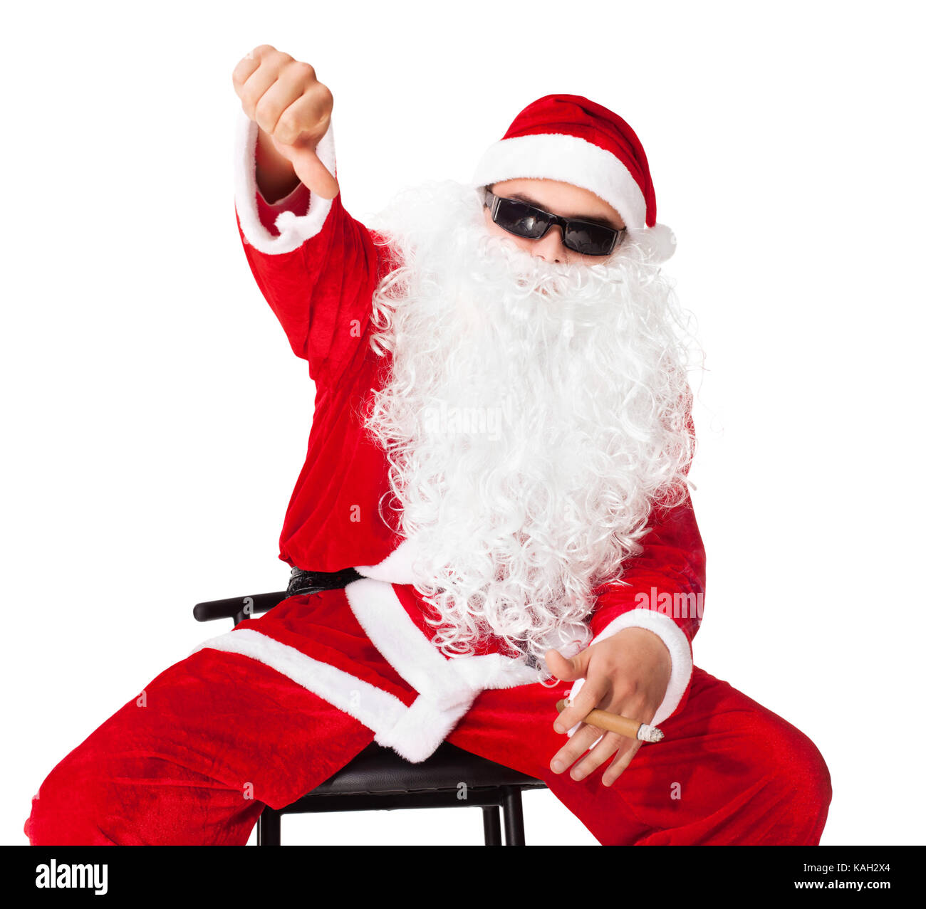 Santa Claus auf einem Stuhl sitzend mit Sonnenbrille Daumen nach unten und das Rauchen einer Zigarre auf weißem Hintergrund angezeigt. Stockfoto