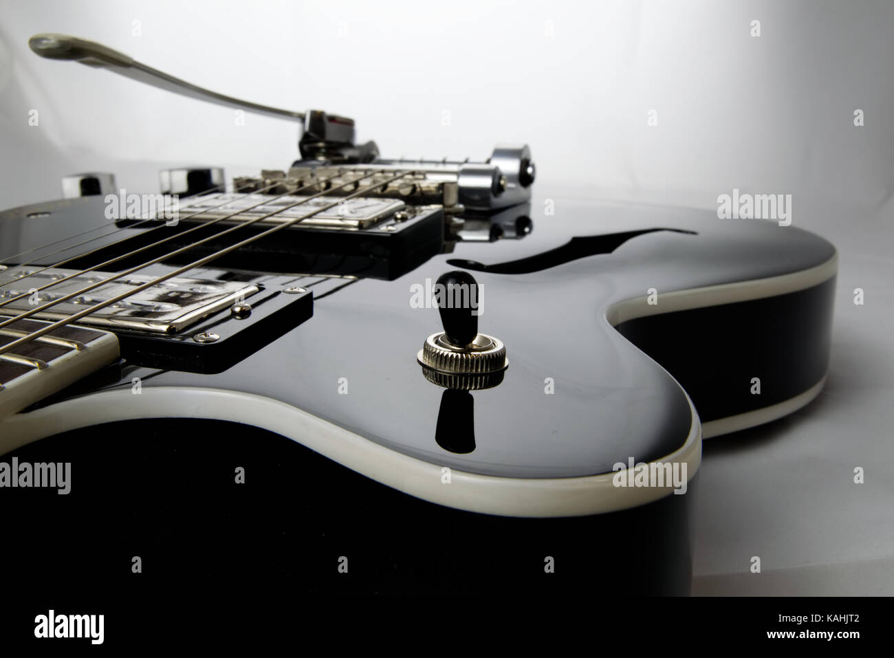 Schwarze Gitarre schließen bis auf Hintergrund isoliert Stockfoto