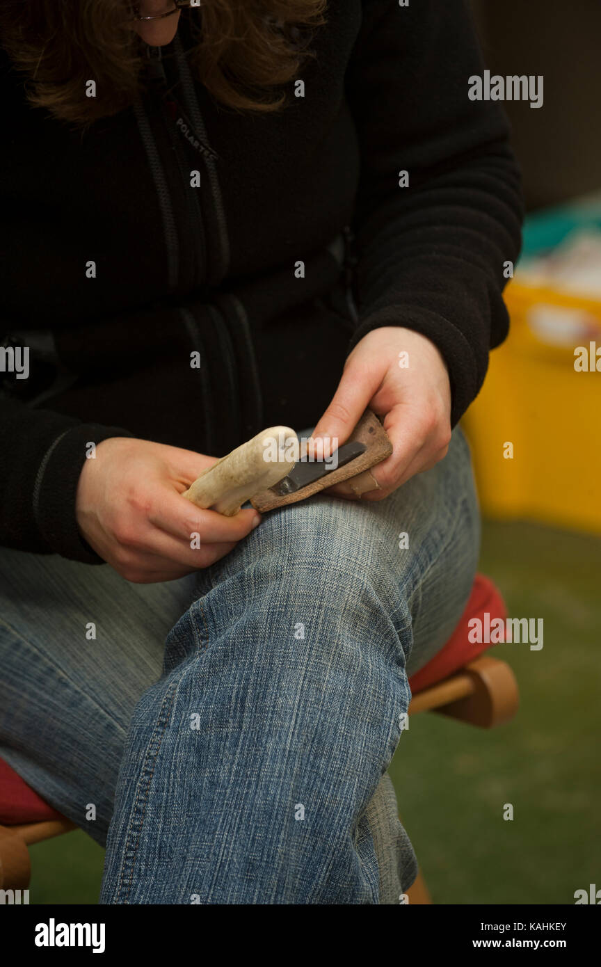 Feuerstein-Knapping-Demonstration, indem man lernt, mit Knochenwerkzeugen von Hand eine Pfeilspitze aus Feuerstein zu machen Stockfoto