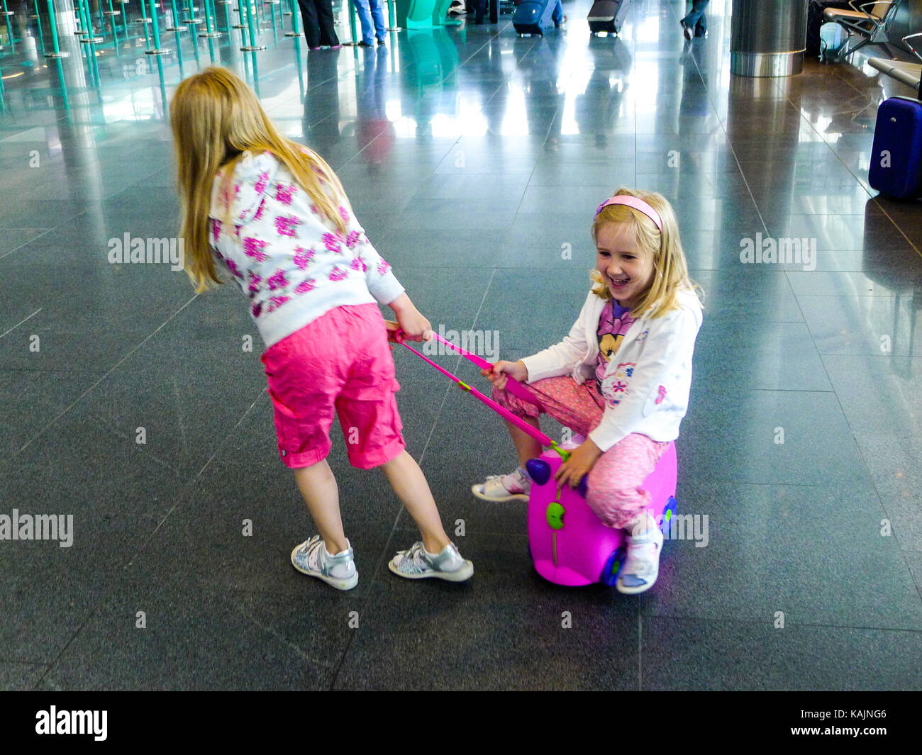 Kinder Spaß auf einem trunki am Flughafen Travel Concept, reisen Touristen Urlaub Koffer räder Kinder Freude glücklich Glück Stockfoto