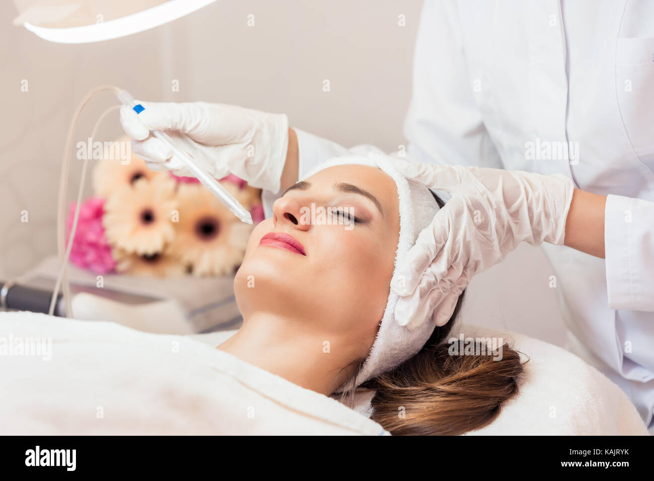 Schöne Frau Entspannung während nicht-invasive Gesichtsbehandlung für Verjüngung in ein modernes Beauty Center mit innovativer Ausstattung Stockfoto