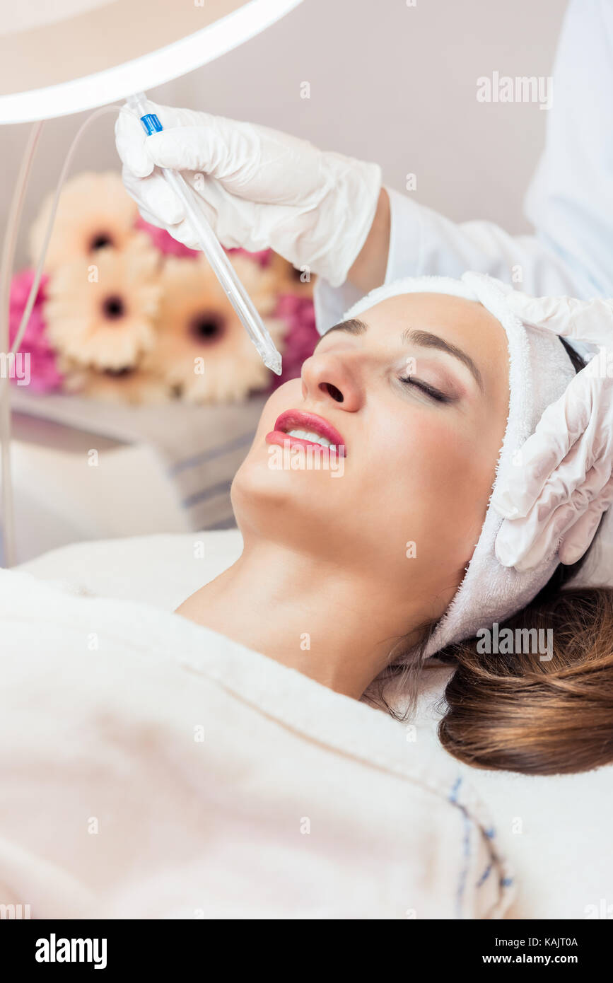 Schöne Frau Entspannung während nicht-invasive Gesichtsbehandlung für Verjüngung in ein modernes Beauty Center mit innovativer Ausstattung Stockfoto