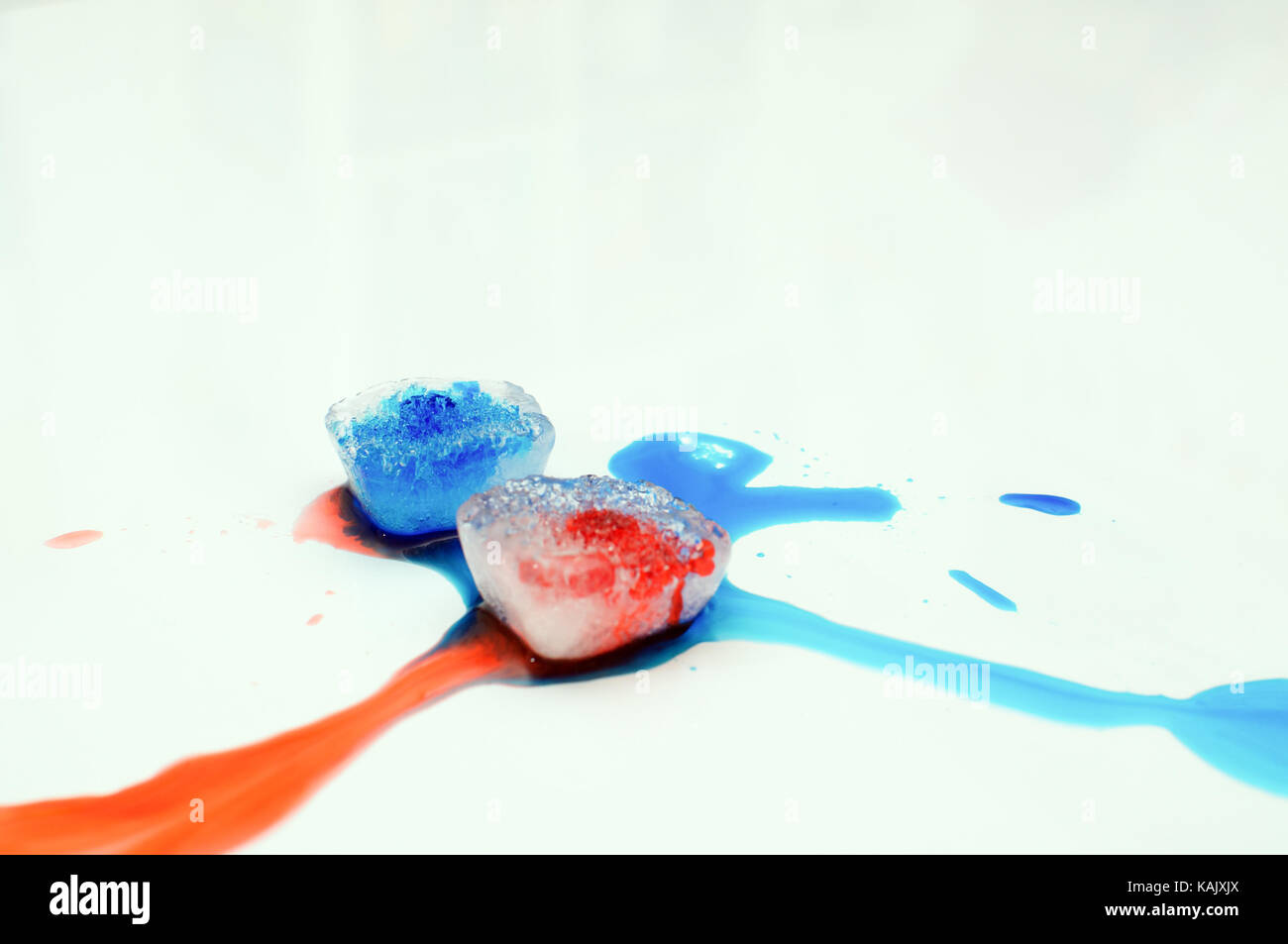 Eiswürfel mit Lebensmittelfarbe auf weißem Hintergrund Stockfoto