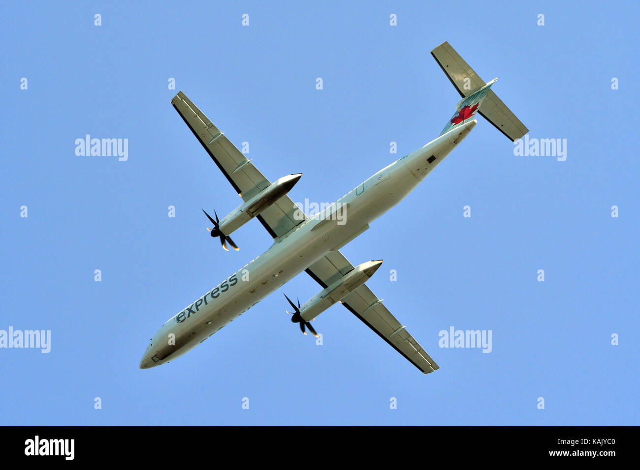 Die Unterseite eines Air Canada Passagiermaschine als IT-Gemeinkosten fliegt vor einem blauen Himmel. Stockfoto