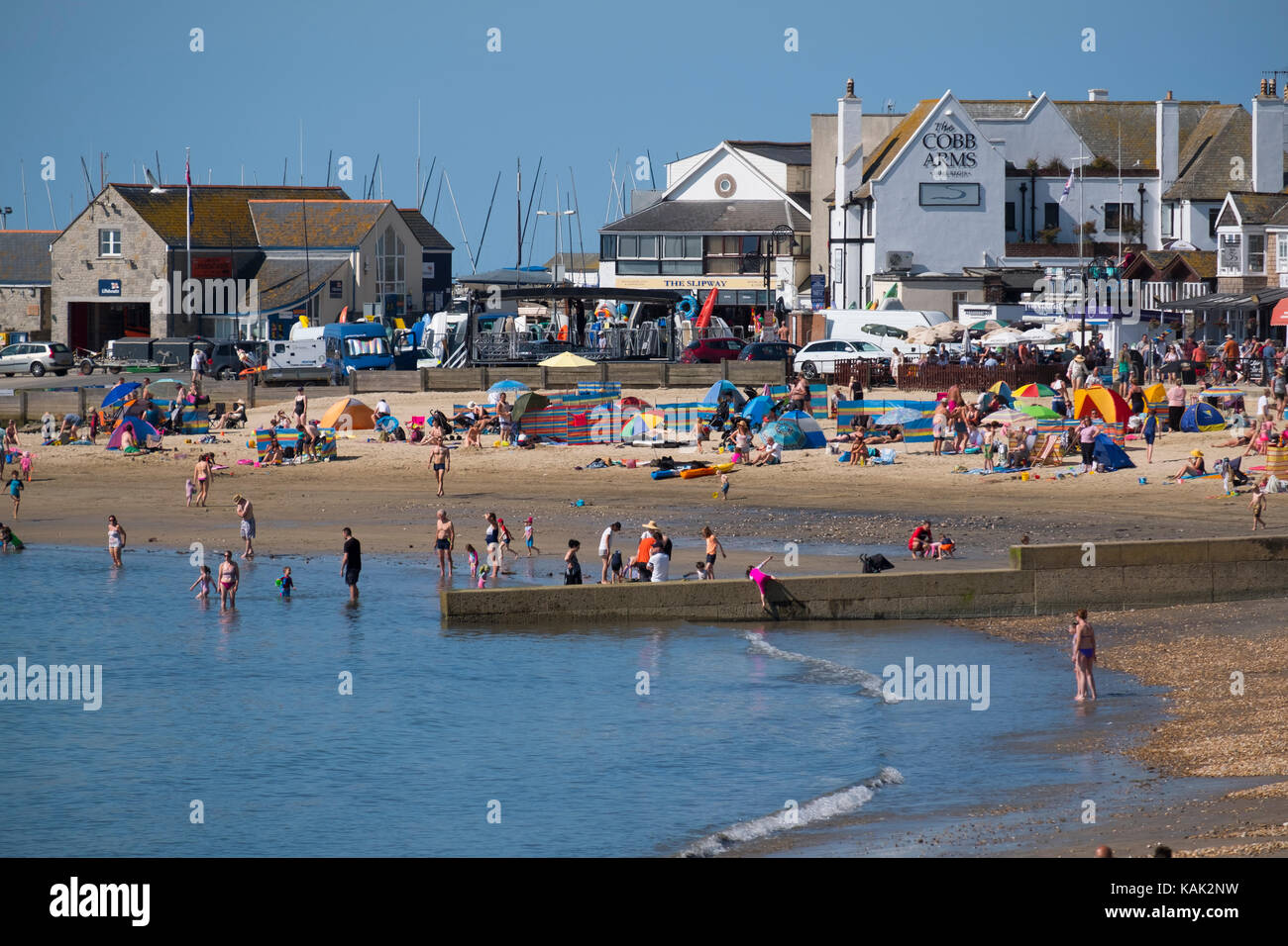 Leute genießen Sommer Sonnenschein am Strand von Lyme Regis, Dorset, Großbritannien. Stockfoto