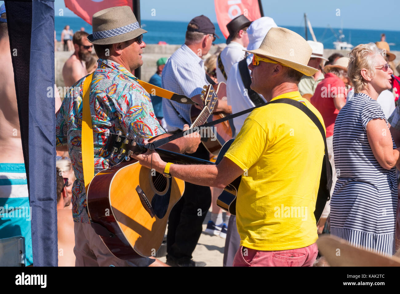 Die Gitarristen spielen an der Gitarre am Strand Veranstaltung in Lyme Regis, Dorset, Großbritannien. Stockfoto