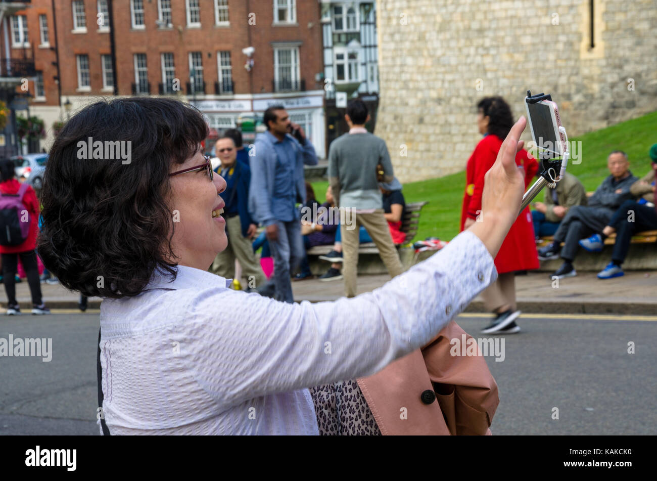 Eine asiatische Dame nimmt ein selfie vor Windsor Castle. Stockfoto