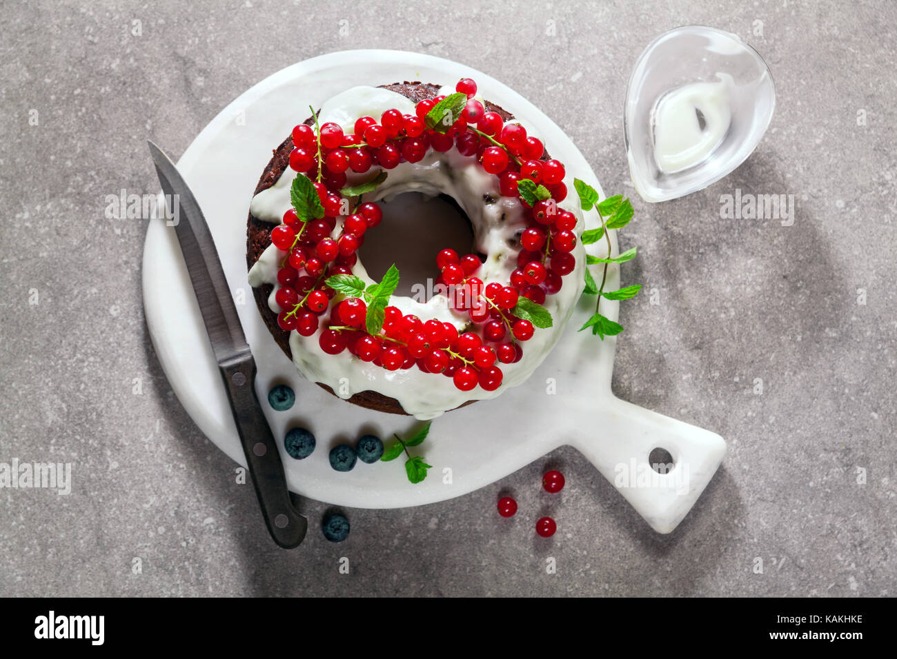 Bundt Cake mit frischen Beeren und Sauce aus saurer Sahne am grauen ...