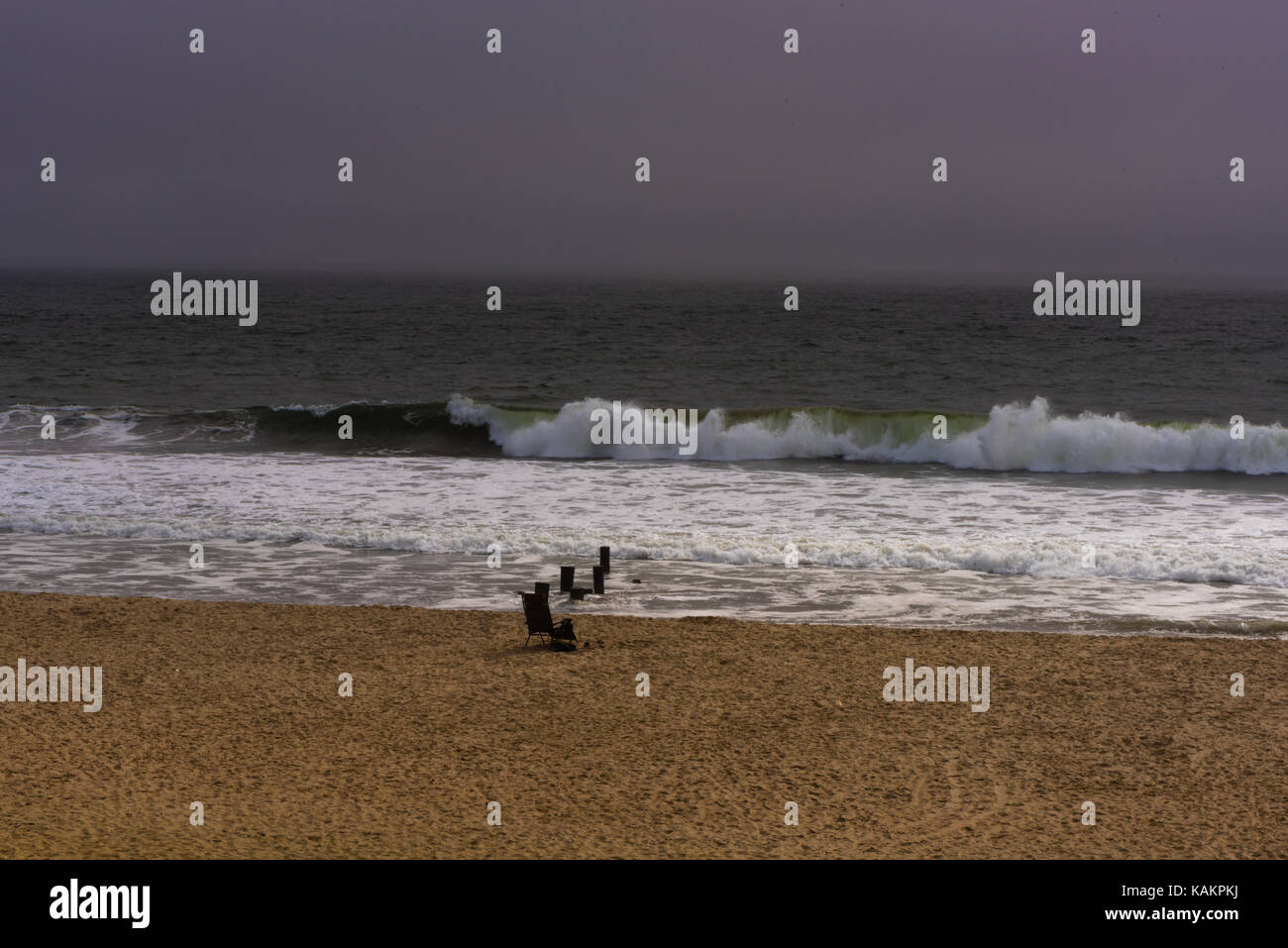 Wellen in den Strand an einem kalten Grauen regnerischen Morgen Stockfoto