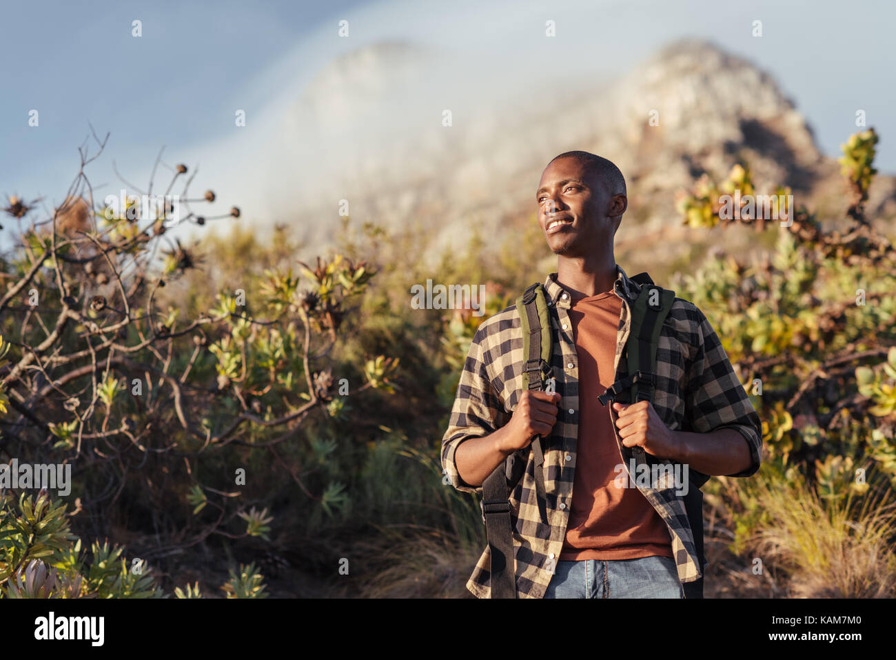 Lächelnden jungen afrikanischen Mann heraus für eine Bergwanderung Stockfoto