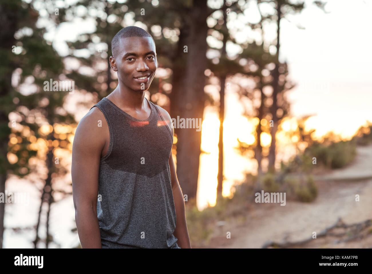 Lächelnd afrikanischen Mann stand auf einem Trail beim Joggen Stockfoto