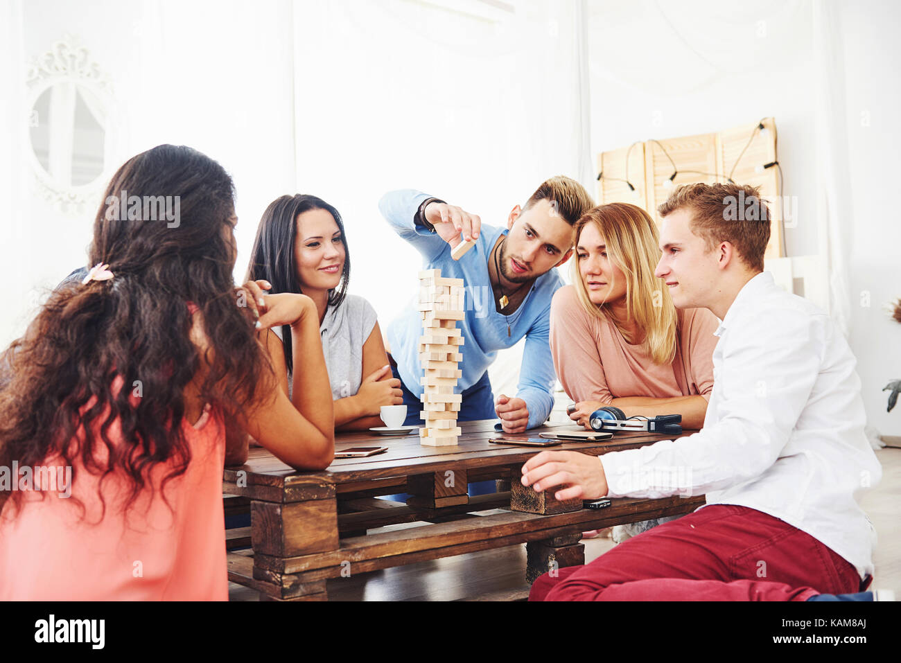 Gruppe der kreativen Freunde an den hölzernen Tisch sitzen. Menschen Spaß beim spielen