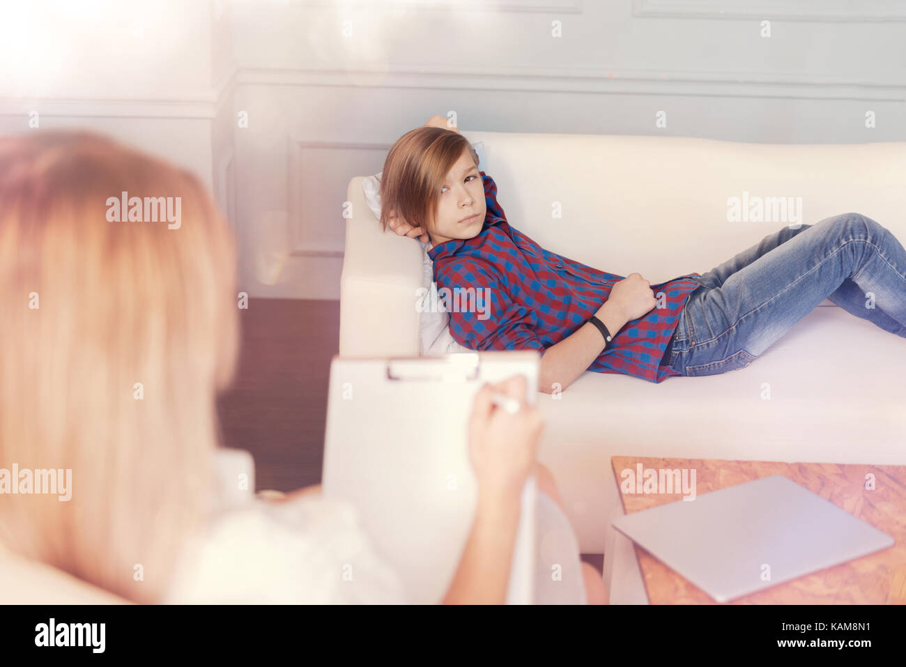 Troubled Teenager auf der Couch liegen während der psychologischen Sitzung Stockfoto