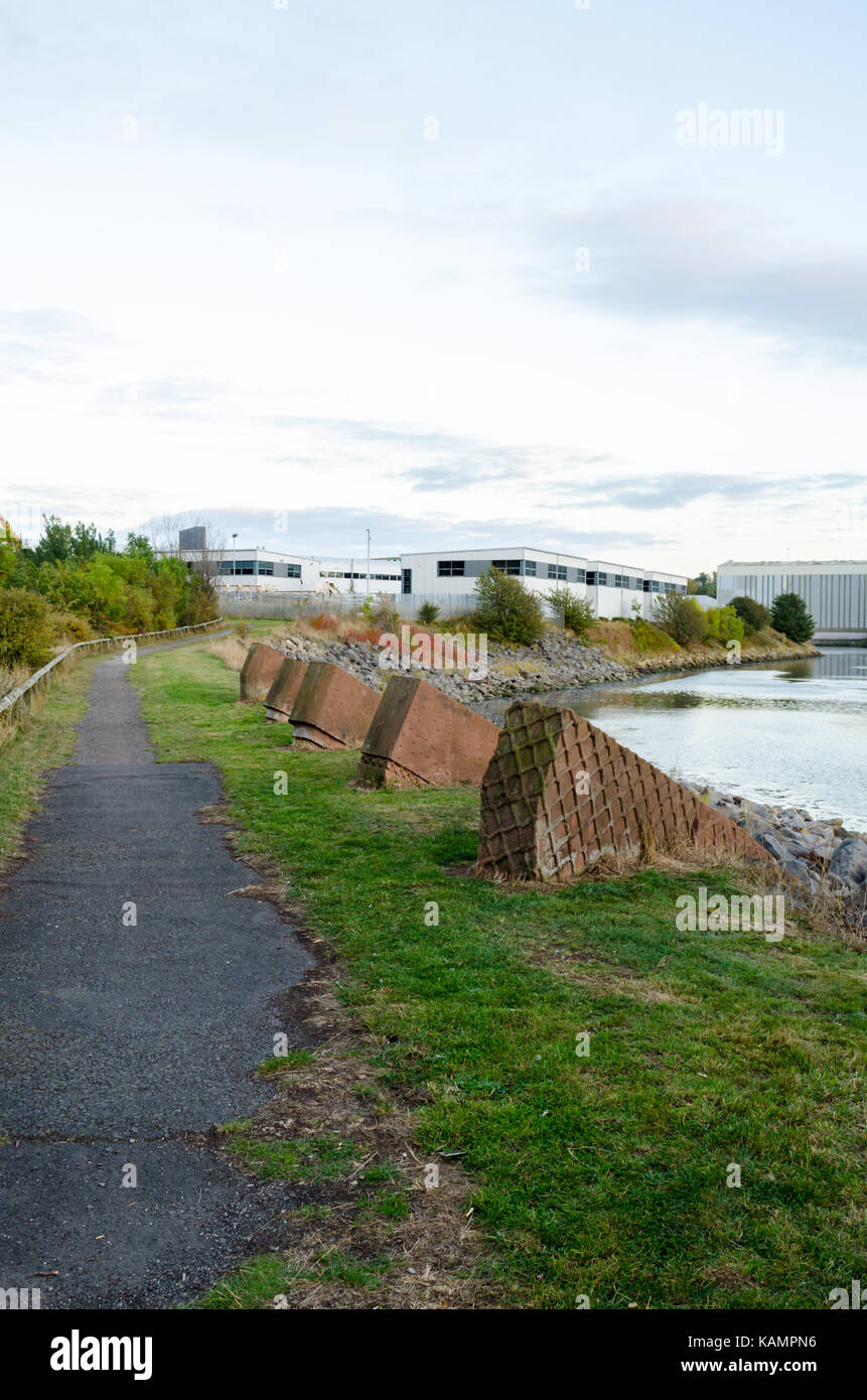 Gehweg entlang der Nordseite des Flusses mit roten beton Skulpturen in den Vordergrund Verschleiß Stockfoto