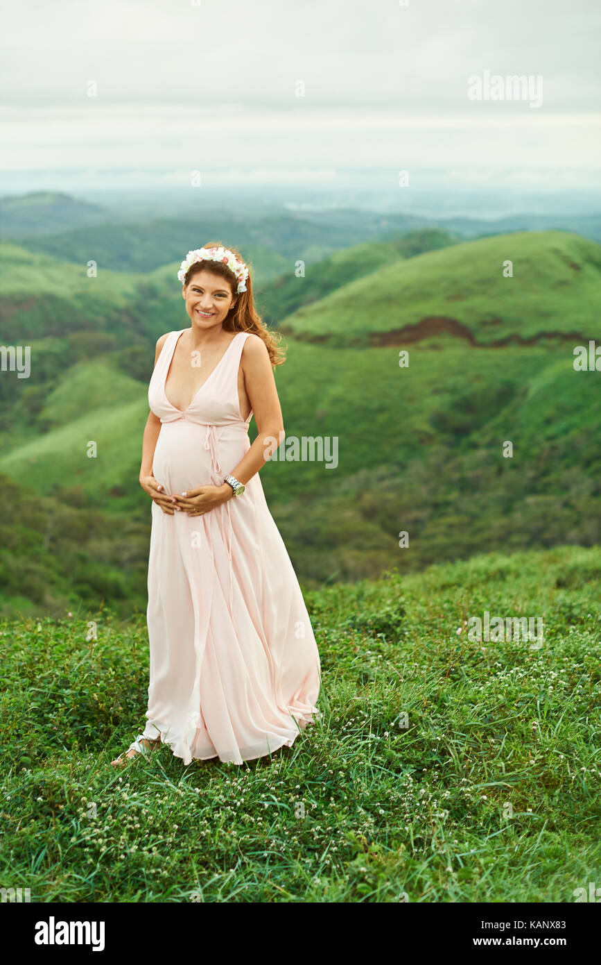 Glücklich lächelnde Hispanic Frau stehend auf dem Grünen Hügel Natur Stockfoto