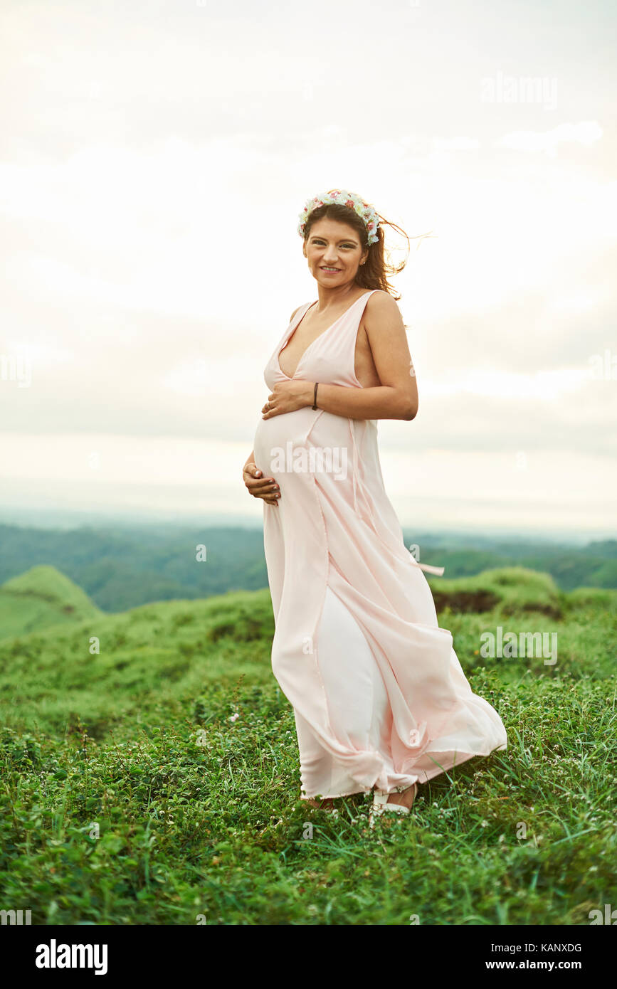 Eine glückliche junge Schwangere latino Frau, die außerhalb Stockfoto