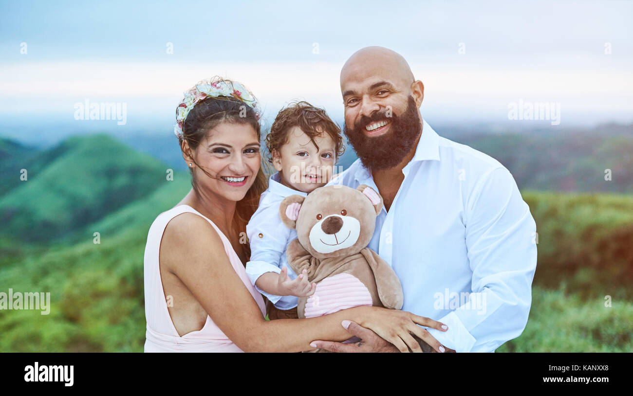 Lächelnden jungen Latino Familie auf natürliche verschwommenen Hintergrund Stockfoto