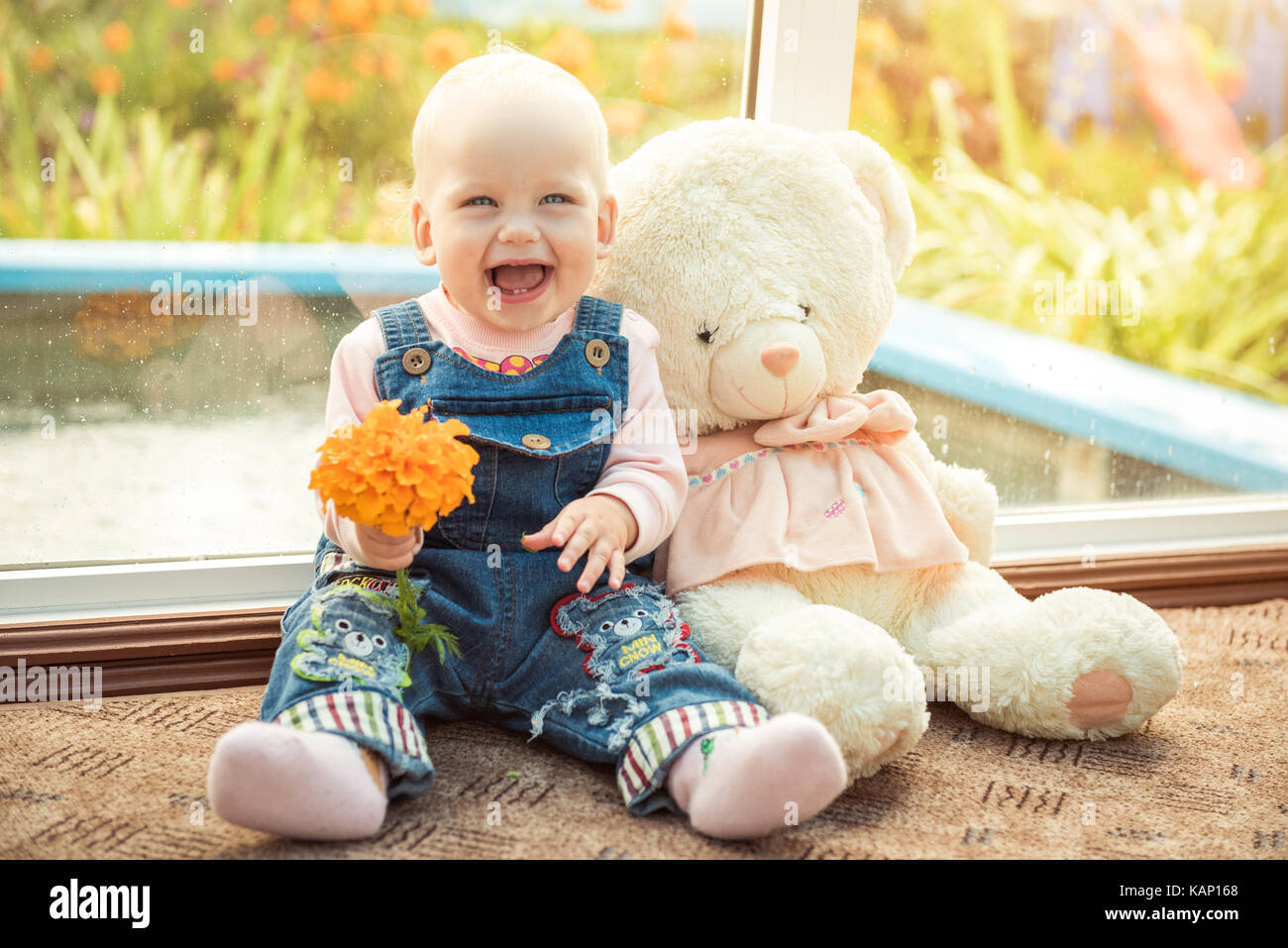 Baby und Teddybär Freunde zu Hause mit Blume Stockfoto