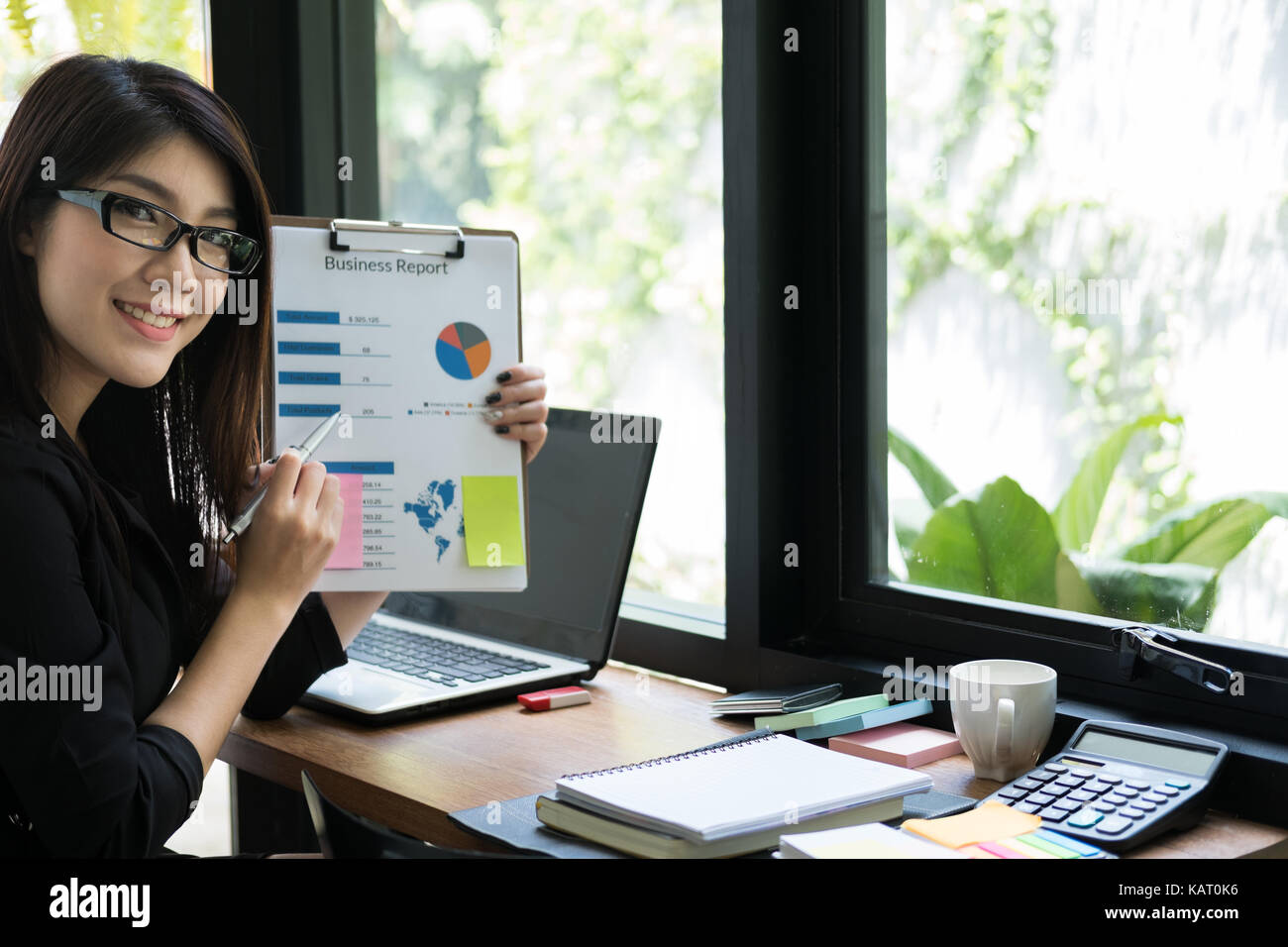 Geschäftsfrau planen neue Business Projekt am Arbeitsplatz. Frau zeigt Market Data Report im Büro. Junge Finance Analyst arbeiten mit finanziellen Grafik & char Stockfoto