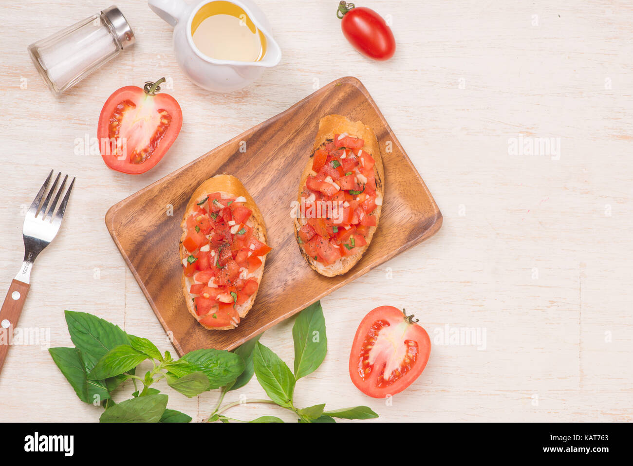 Vorbereitung köstliche italienische Tomaten Bruschetta mit gehacktem Gemüse, Kräutern und Öl Stockfoto