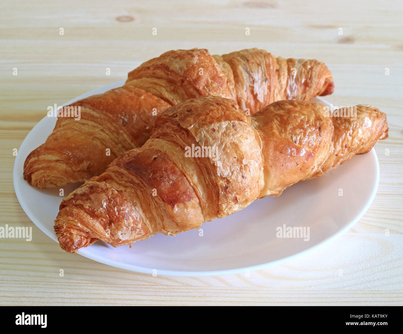 Paar frische ganze Weizen Croissants Gebäck serviert auf einem weißen Teller Stockfoto