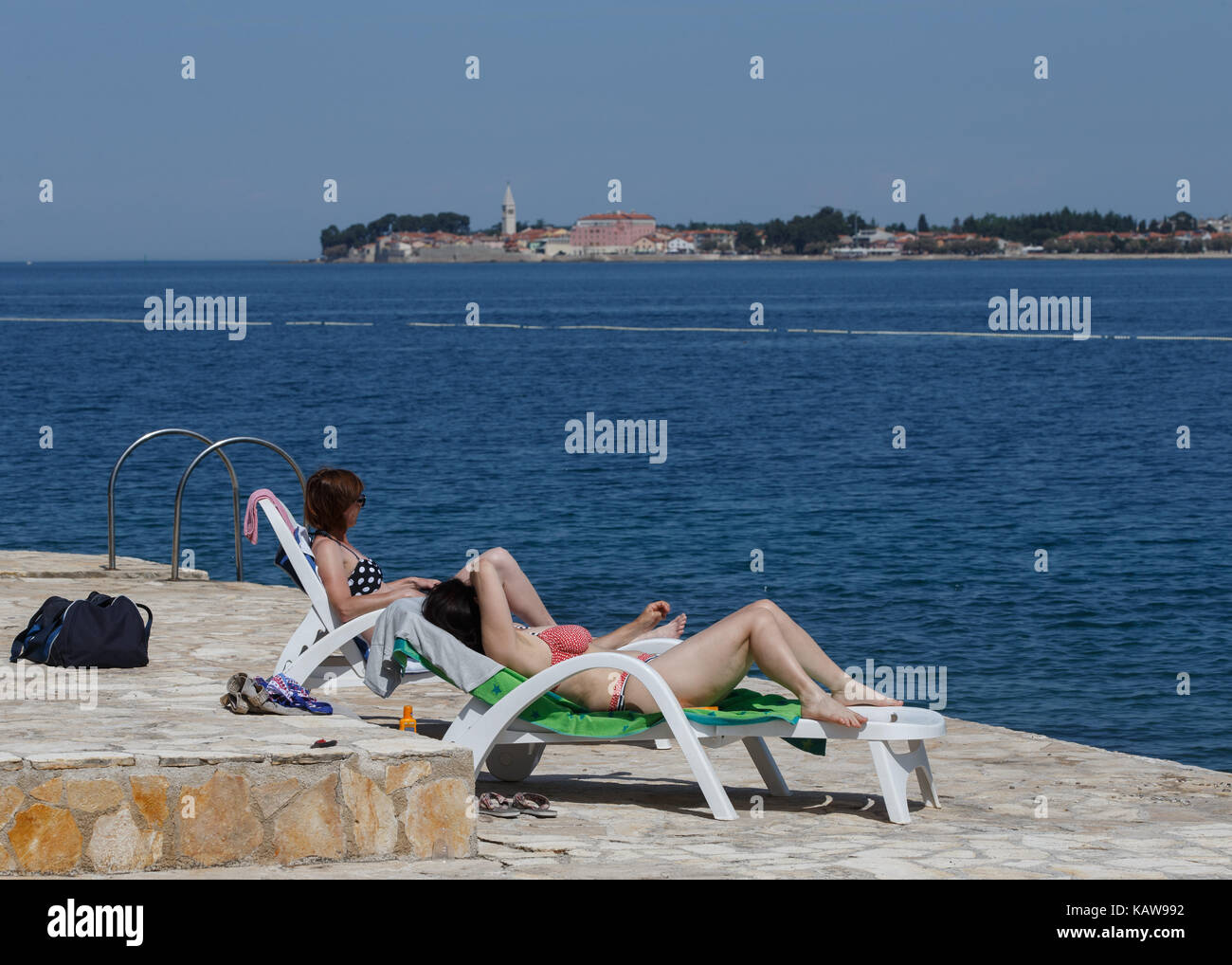 Touristen entspannen im Liegestuhl am Strand, Lanterna, Novigrad, Kroatien. Stockfoto