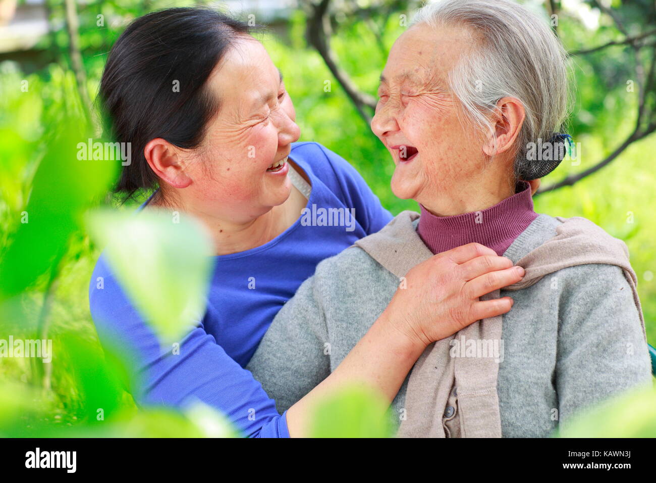 Foto von einem ausgereiften chinesische Frau mit ihrem älteren Mutter draußen im Hof Stockfoto